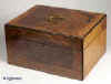  JB305: Antique box veneered with highly figured walnut, the top and front having a central panel framed by a crossbanding of straight grained walnut and having an inlayed brass line, the box opening to a velvet (replacement) lined liftout  tray. The inside of the lid is lined with lined with red satin which is button padded. There is a countersunk carrying handle to the top. The box is edged with ebony and has a working lock and key.  Circa 1890. Enlarge Picture