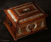 TC566: Monumental three canister tea chest in figured rosewood on a mahogany carcass with mother of pearl inlay standing on turned rosewood feet having turned rosewood drop ring handles. The shape of this chest combines elements and influences characteristic of the  nineteenth century. It is structured in an   ancient Egyptian architectural form combining tapered  and pyramid lines which make this caddy a strong statement of the robust and elegant style of the Regency. The composition of the top is strong. The inlaid mother of pearl inlay  panels are set off by a further stringing of white-metal. (pewter).  circa 1830.  Enlarge Picture